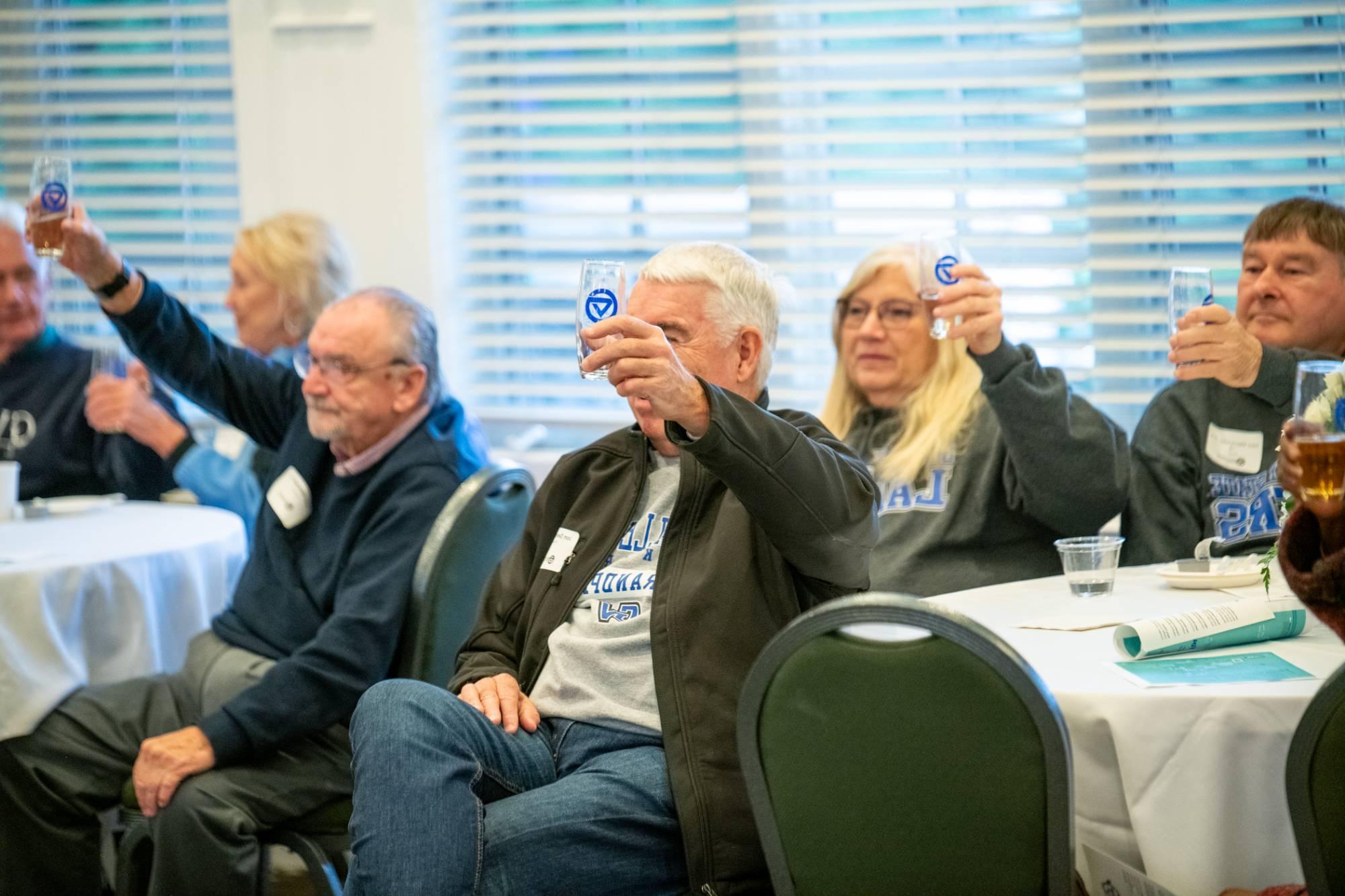 Alumni raising a toast at breakfast.